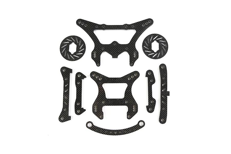 A set of Rovan carbon fibre RC car parts including shock towers, braces, and brake discs laid out on a white background.
