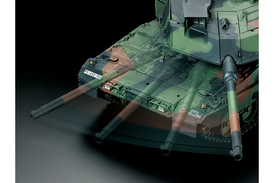Close-up of a Tamiya Leopard 2 A7V RC tank model showing the turret and hull with a digital overlay illustrating the main gun's range of motion.