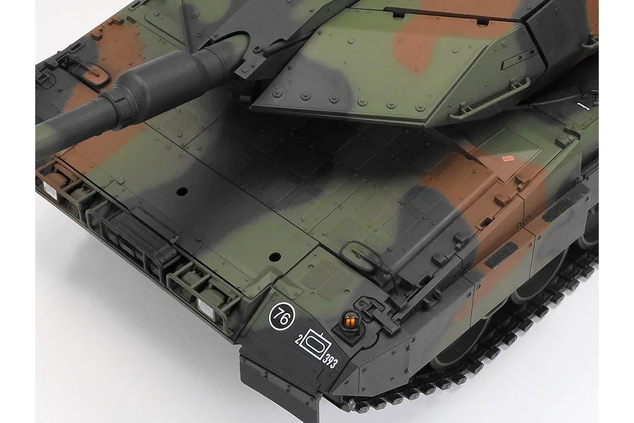 Close-up of the front hull and turret of a Tamiya Leopard 2 A7V RC tank model with a detailed camouflage paint scheme.