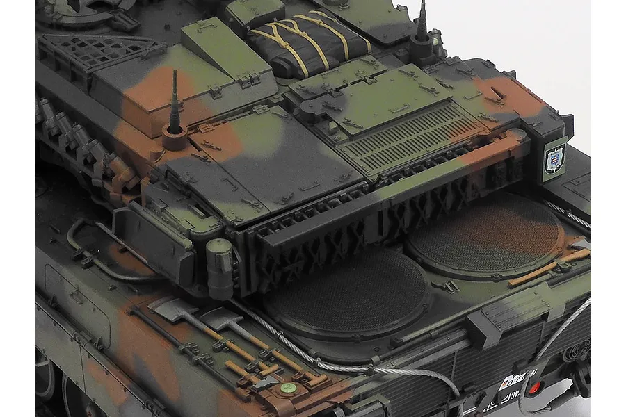 Close-up of the rear engine deck and turret of a Tamiya 1/16 scale Leopard 2 A7V RC tank model with detailed camouflage paint and scale accessories.