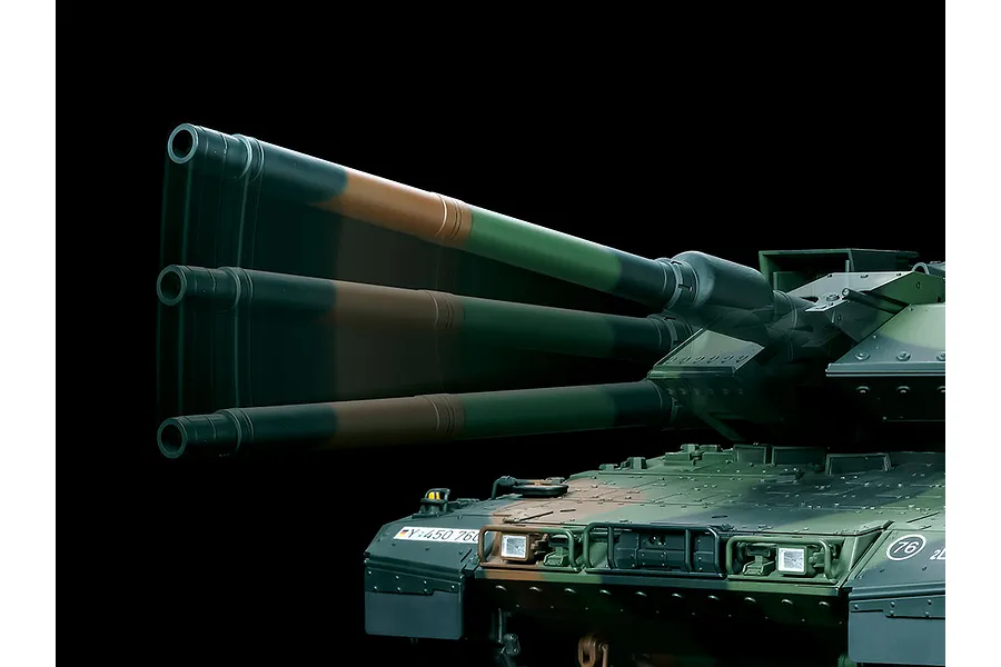 Close-up of a Tamiya Leopard 2 A7V RC tank model showing the turret and main gun barrel with a motion blur effect against a black background.