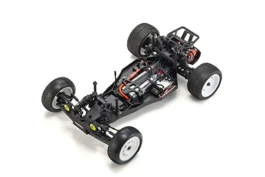 High-angle studio shot of a Kyosho Ultima SB Dune Master 2WD RC buggy chassis showing internal components, suspension, and white wheels on a white background.