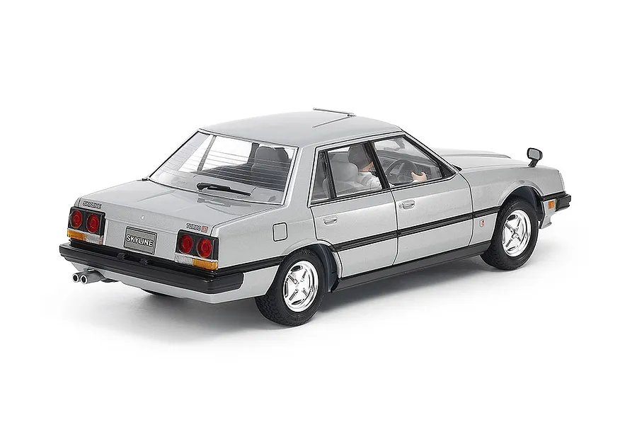 A rear three-quarter view of a silver Tamiya 1/24 scale Nissan Skyline 2000 Turbo GT-E S sedan plastic model kit, showing detailed exterior and interior.