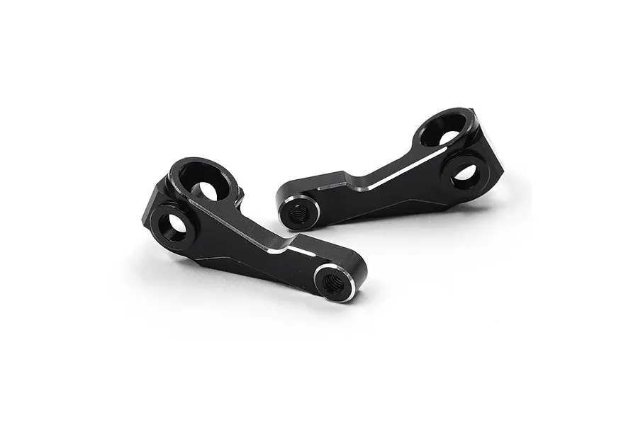 Two black anodized aluminium front steering hubs for RC cars, featuring machined silver edges and multiple mounting holes.