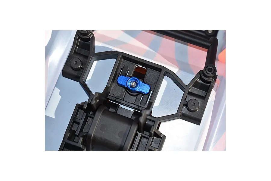 A blue aluminium body shell lock installed on a black plastic RC car body mount structure.