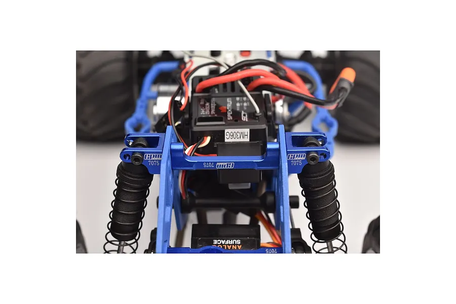 Close-up of blue anodized aluminium GPM Racing shock mounts installed on an RC vehicle chassis.