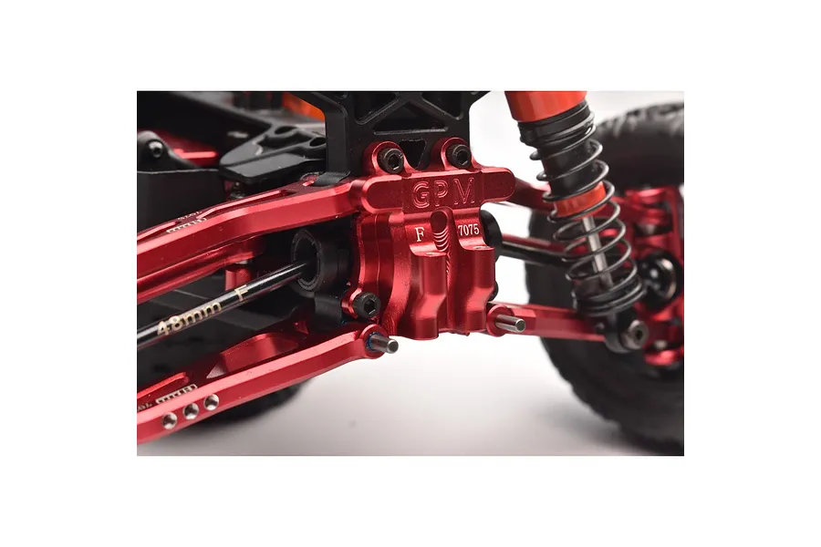 A close-up view of a red anodized aluminium front differential cover installed on an RC car chassis, featuring GPM branding and 7075 markings.