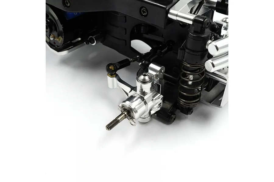 Close-up of a silver aluminium front hub carrier installed on an RC car chassis, showing the steering knuckle and suspension components.