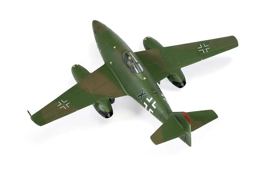 A high-angle studio shot of a finished 1/72 scale plastic model of a Messerschmitt Me 262 jet fighter, painted in green and brown camouflage.