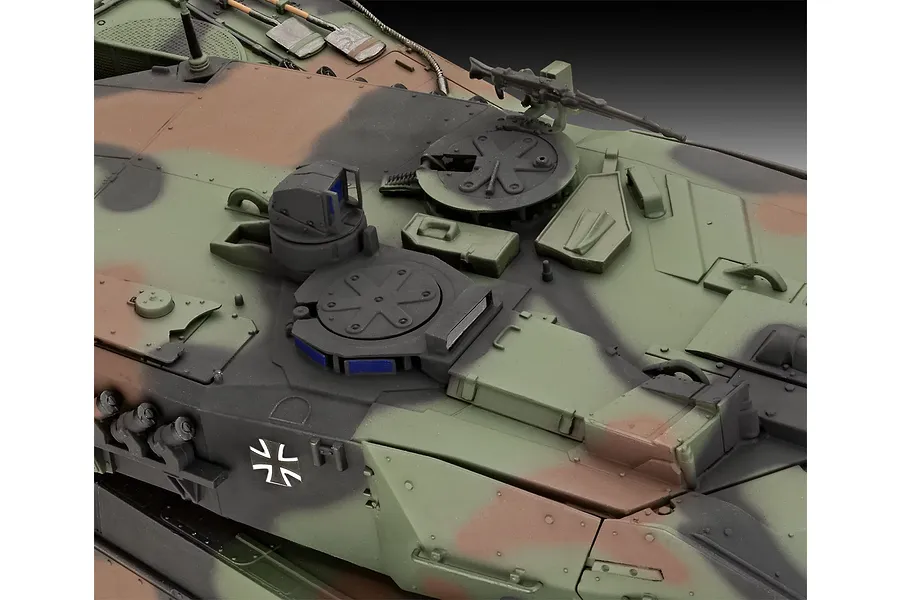 Close-up of the turret top of a 1/35 scale Leopard 2A6M+ model tank featuring camouflage paint and German military markings.