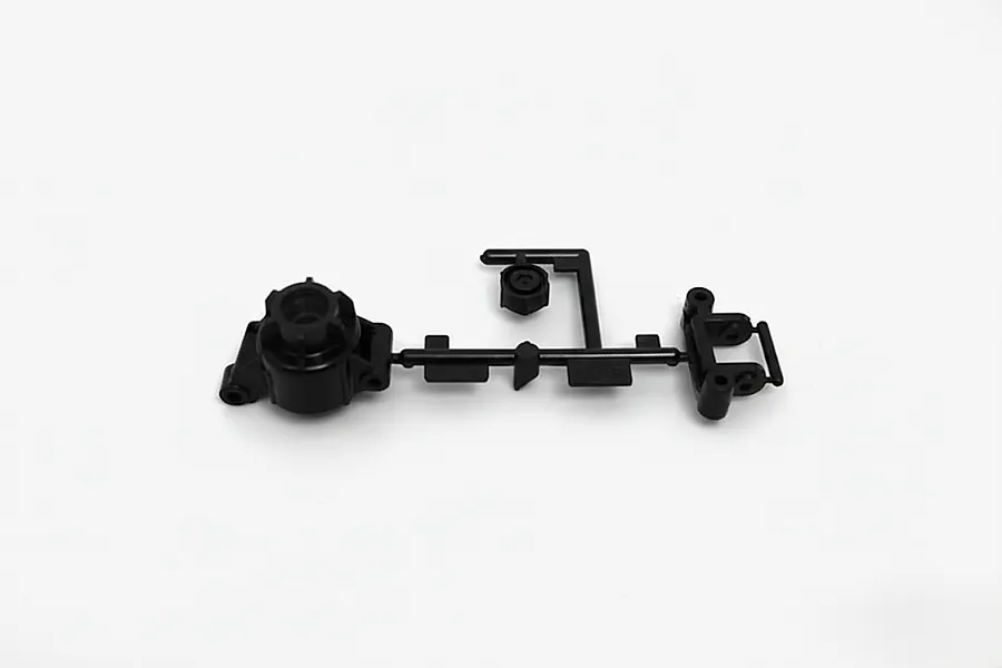 A black plastic Tamiya RC car spare part tree containing a rear hub, hub carrier, and hex adapter on a plain white background.