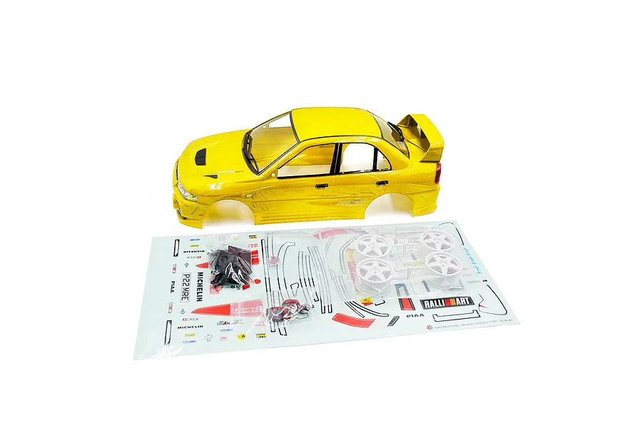 A yellow 1/10 scale Mitsubishi Lancer Evo IV RC body shell with white rims and a decal sheet on a white background.