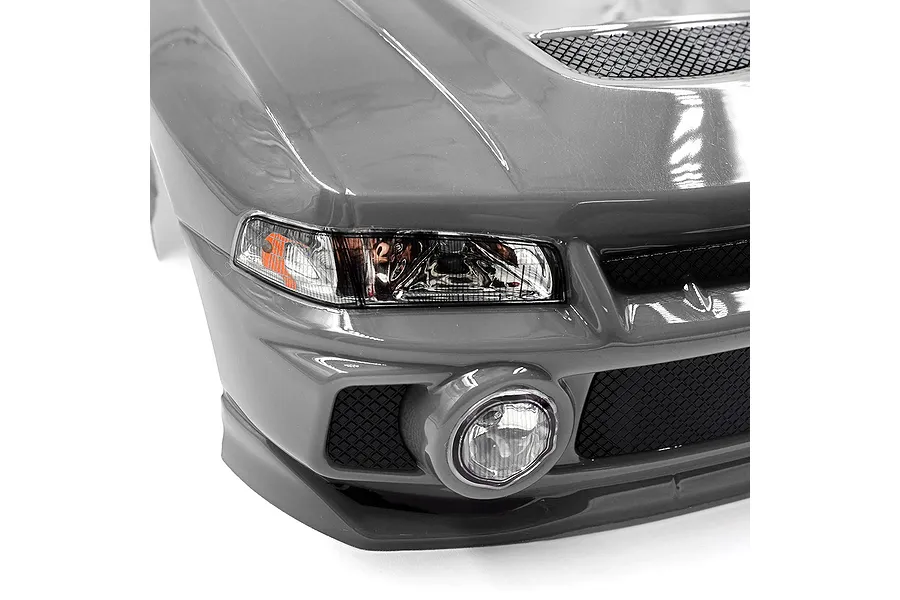 Close-up of the front bumper and headlight of a silver 1/10 scale Mitsubishi Lancer Evo IV RC car body shell.