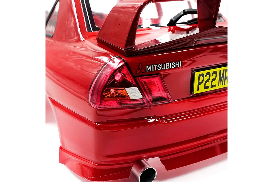Close-up of the rear section of a red 1/10 scale Mitsubishi Lancer Evo IV RC car body shell, showing the tail light, spoiler, and exhaust pipe.