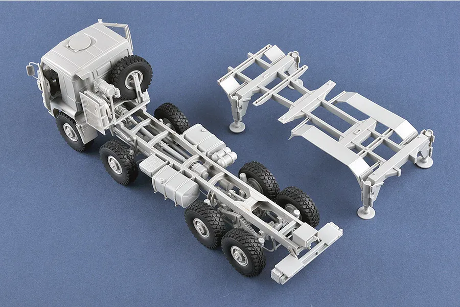 A high-angle view of an unpainted plastic model truck chassis and a separate frame section for a 1/35 scale Trumpeter Pantsir-S1 model kit.