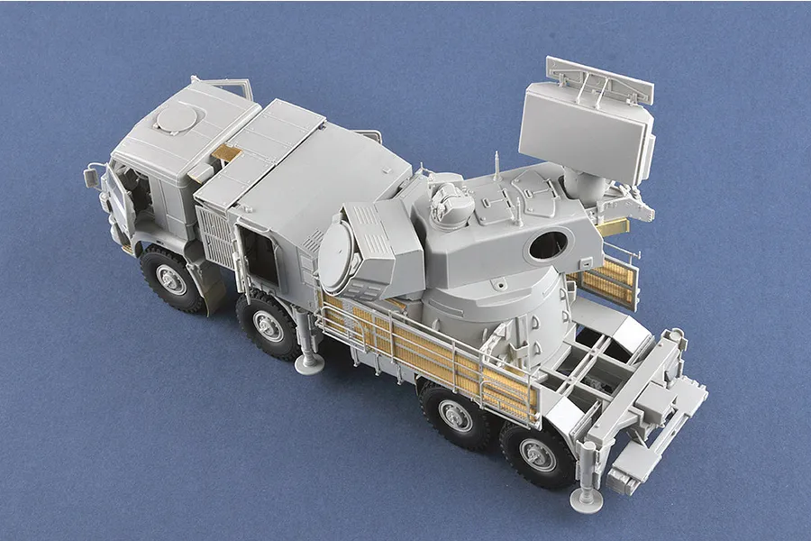 High-angle view of an unpainted grey plastic model of a Pantsir-S1 air defense vehicle with photo-etched metal detailing.