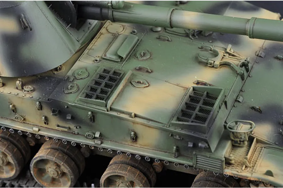 Close-up of a 1/35 scale model of a Soviet 2S3 self-propelled gun showing the detailed engine deck, turret, and camouflage paint scheme.