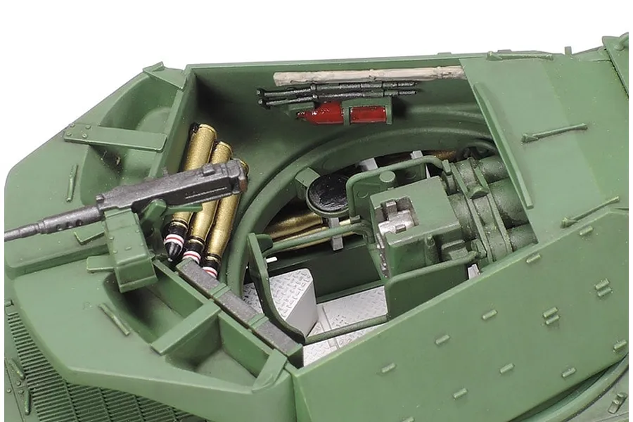 Close-up view of the open turret interior of a Tamiya 1/48 scale British M10 IIC Achilles tank model, showing detailed ammunition, a machine gun, and fire extinguisher.