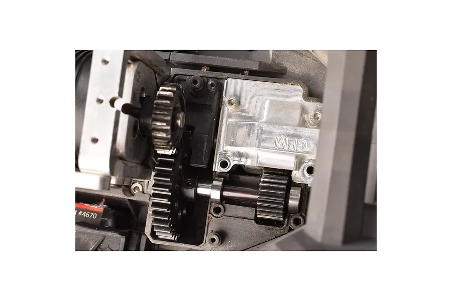 Close-up of a GPM Racing spur gear installed in an RC car drivetrain assembly.