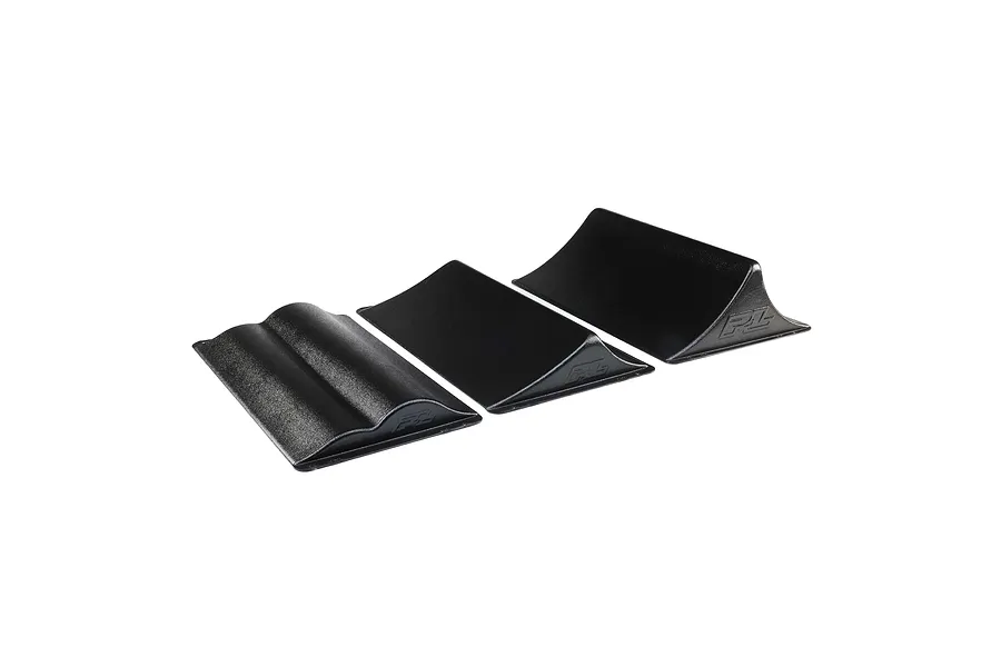 Three black Pro-Line RC ramps arranged on a white background, including a curved jump and two standard ramps with embossed PL logos.
