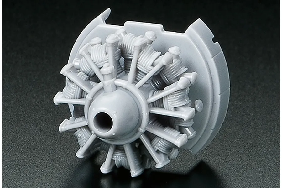 A grey plastic scale model radial engine part for a Tamiya model aircraft kit on a black background.