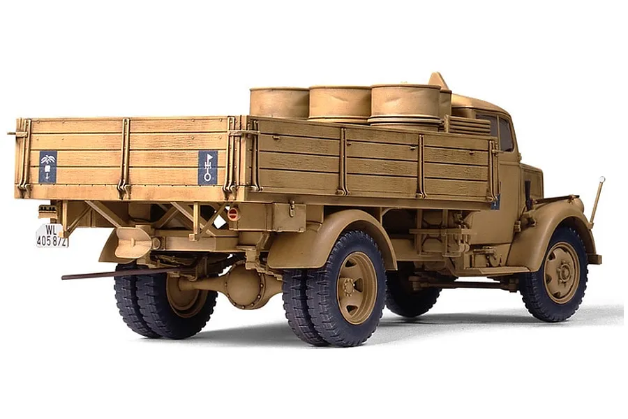 A rear three-quarter view of a 1/35 scale Tamiya German 3 Ton 4x2 cargo truck model, painted in a desert tan camouflage scheme.
