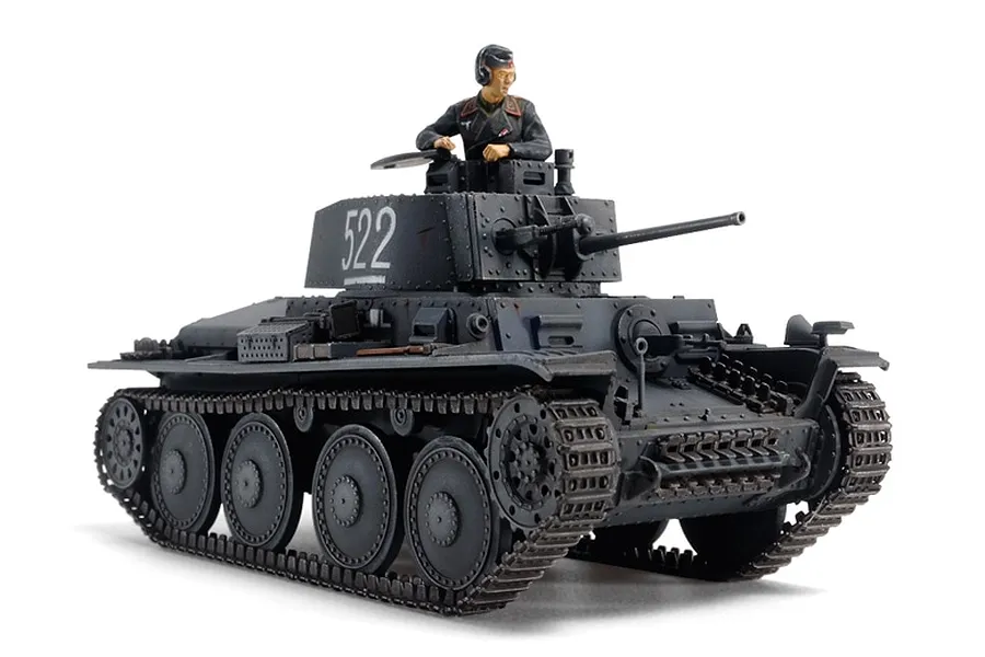 A fully assembled and painted 1/48 scale Tamiya Panzer 38(t) model tank with a commander figure in the turret, isolated on a white background.