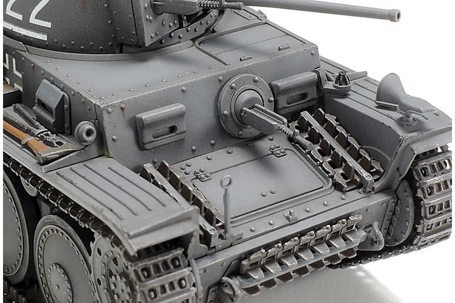 Close-up of a 1/48 scale Tamiya Panzerkampfwagen 38(t) model tank, showing the front hull, turret, and tracks in grey paint.