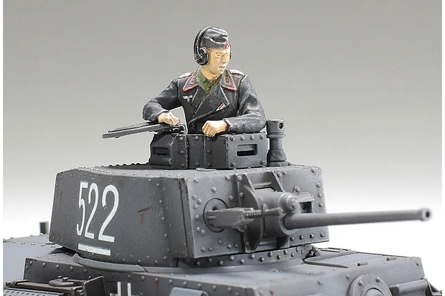 A painted 1/48 scale model tank turret with a German tank commander figure emerging from the hatch.