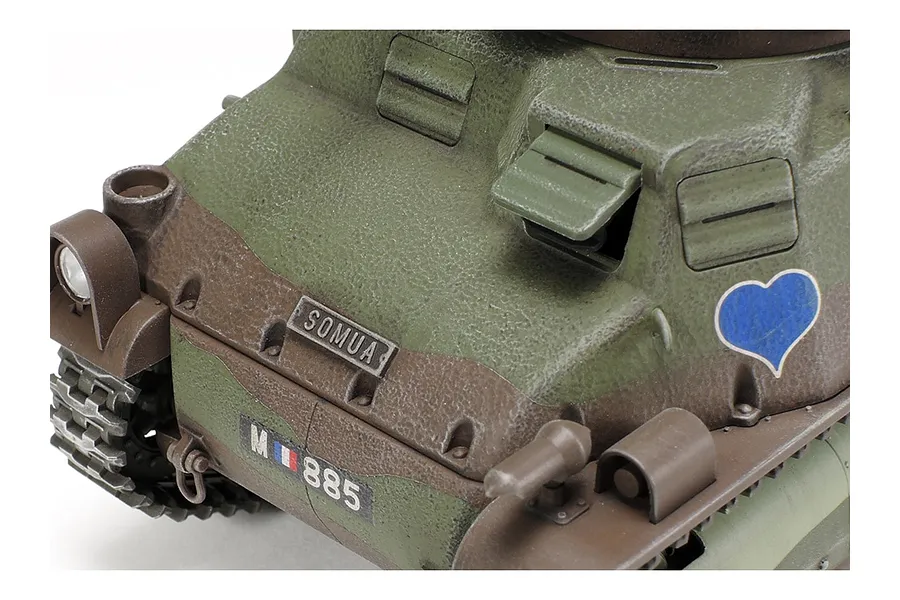 Close-up of a Tamiya 1/35 scale Somua S35 tank model showing the front hull, textured green and brown camouflage, and a blue heart decal.