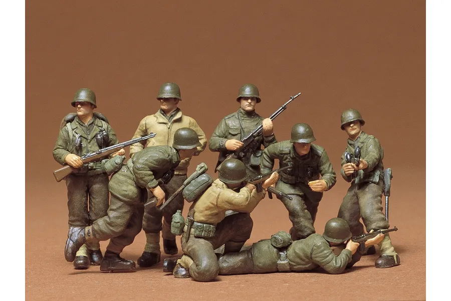 A group of eight painted 1/35 scale Tamiya U.S. Infantry figures in various combat poses against a brown background.