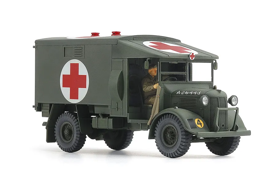 A 1/48 scale plastic model of a British Austin K2 ambulance painted in olive drab with red cross markings and a driver figure inside.