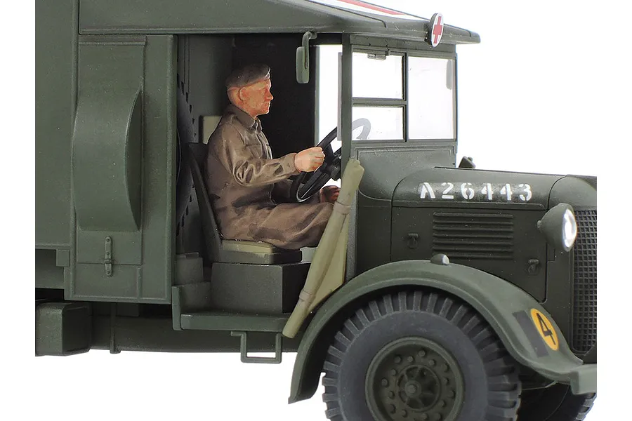 A close-up side view of a Tamiya 1/48 scale British Austin K2 ambulance model, showing the driver figure in the cab and military markings.