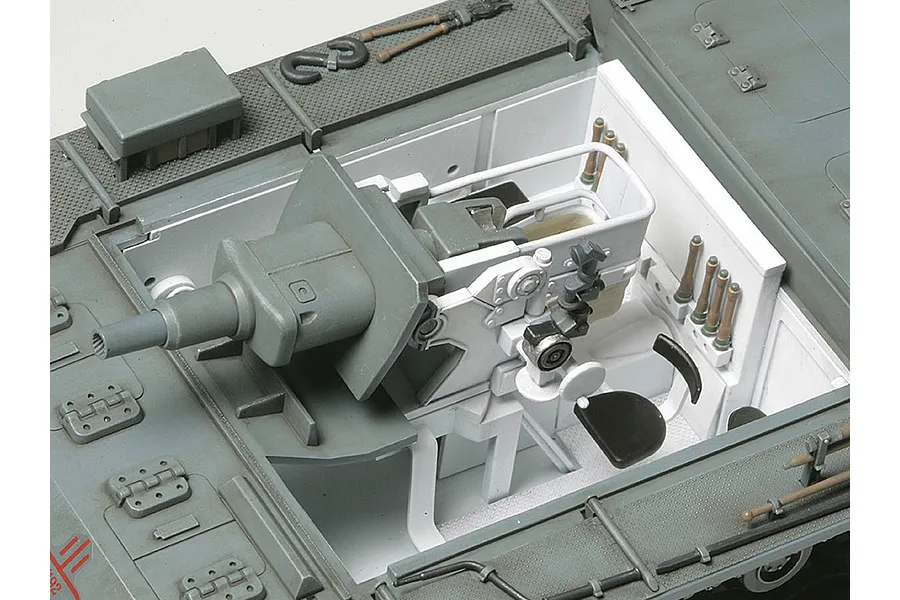 A detailed top-down view of the interior of a 1/35 scale Tamiya Sturmgeschutz III model tank, showing the gun breech, crew seat, and ammunition storage.
