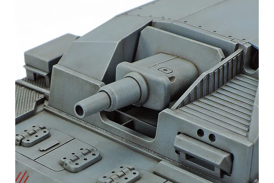 Close-up of the grey plastic gun assembly and front hull of a 1/35 scale Sturmgeschutz III model tank.
