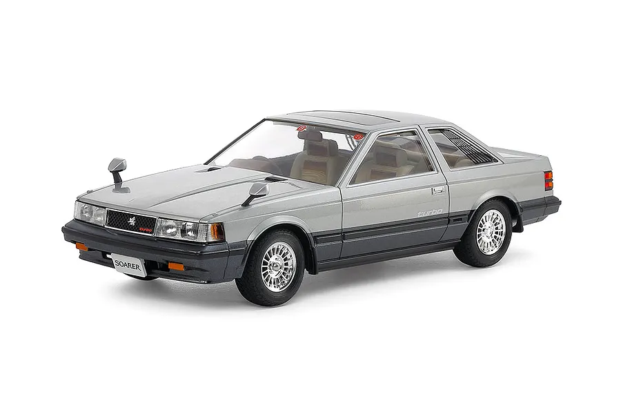 A high-quality studio shot of a 1/24 scale Tamiya Toyota Soarer 2000VR-Turbo model car, painted in a two-tone silver and dark grey finish.