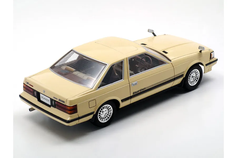 A high-angle rear three-quarter view of a beige Tamiya 1/24 scale Toyota Soarer 2000VR-Turbo plastic model car kit on a white background.
