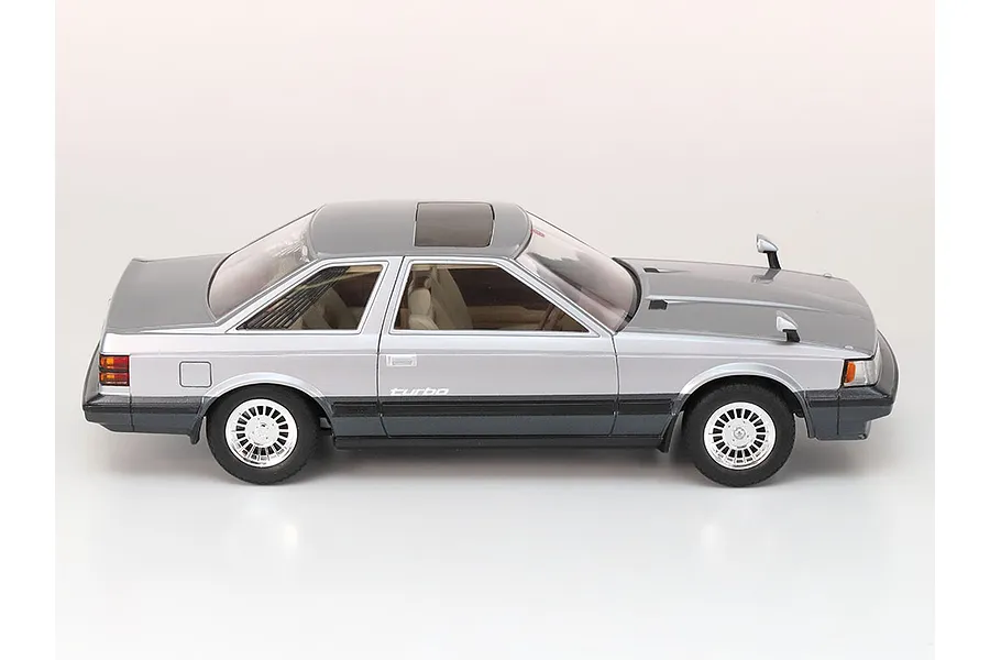 A side profile view of a finished 1/24 scale Tamiya Toyota Soarer 2000VR-Turbo model car, featuring a two-tone silver and dark grey paint scheme.