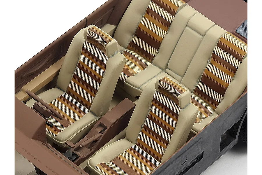 High-angle view of the detailed interior of a 1/24 scale Tamiya Toyota Soarer model car, featuring beige and brown striped seats.
