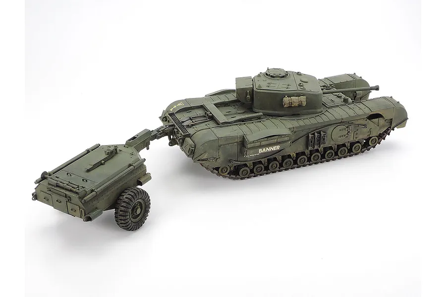 A fully assembled and painted 1/35 scale Tamiya British Churchill Crocodile tank model with its fuel trailer attached, viewed from a high angle.