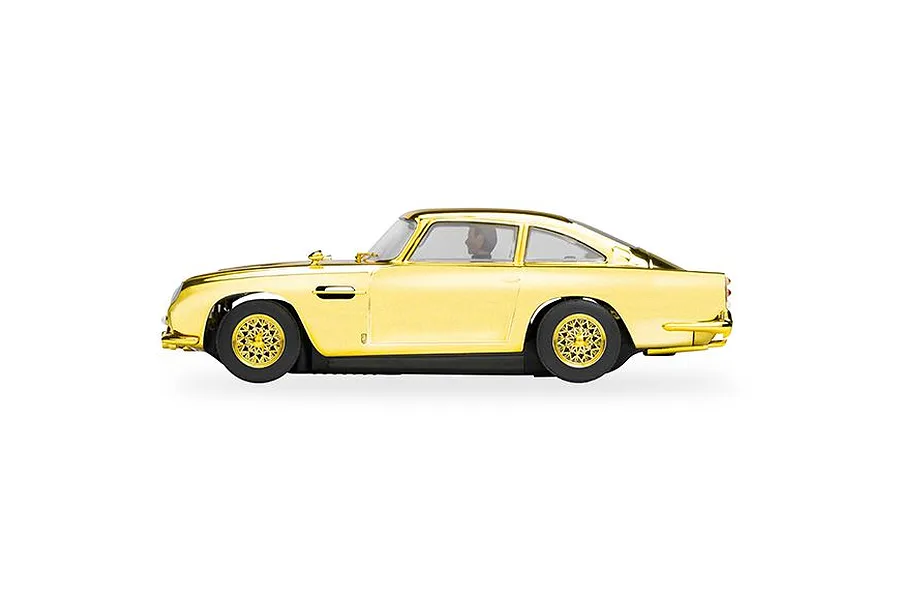 Side profile view of a gold-plated Scalextric 1/32 scale Aston Martin DB5 slot car on a white background.