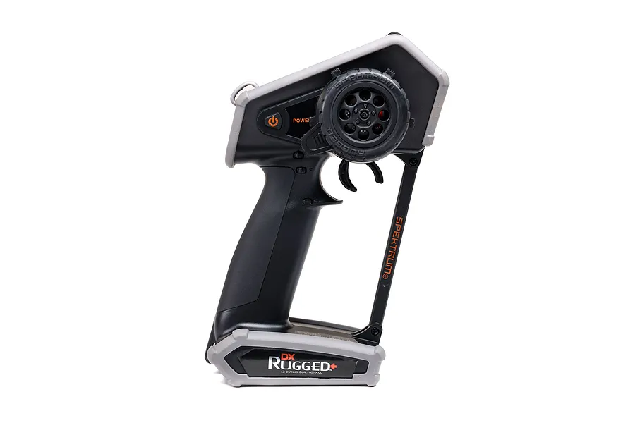 Side profile of a Spektrum DX Rugged+ RC transmitter featuring a black handle, grey protective bumpers, and a steering wheel.