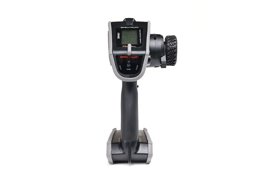 Front view of the Spektrum DX Rugged 12-channel RC transmitter featuring a grey and black protective casing and a steering wheel with a rubber tire grip.