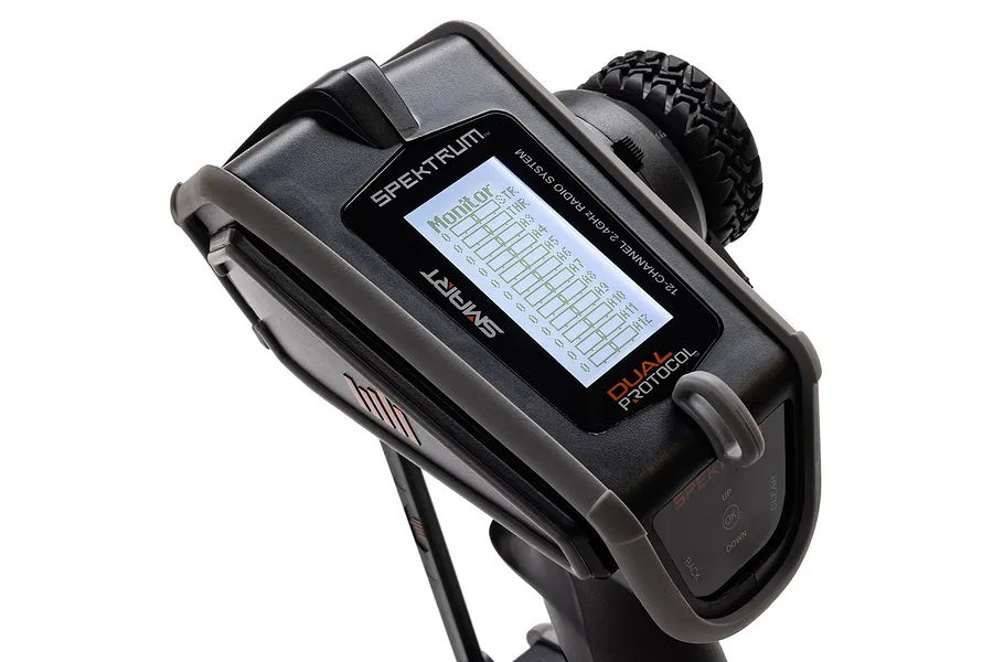 Close-up of the Spektrum DX Rugged radio transmitter showing the LCD screen displaying monitor settings and the rubberized protective casing.