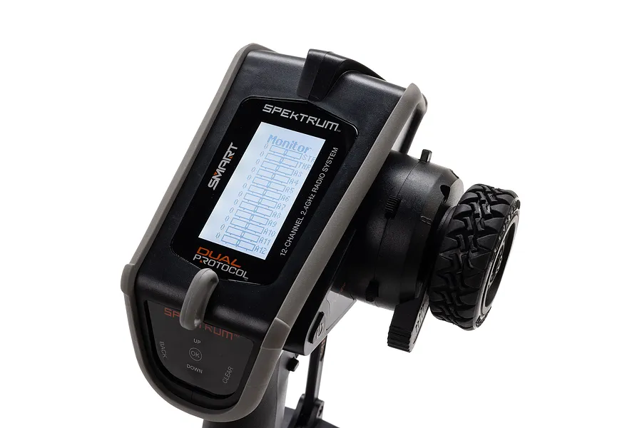 Spektrum DX Rugged 12-channel RC transmitter showing a monitor screen with channel bars, featuring a black and grey ruggedized design.