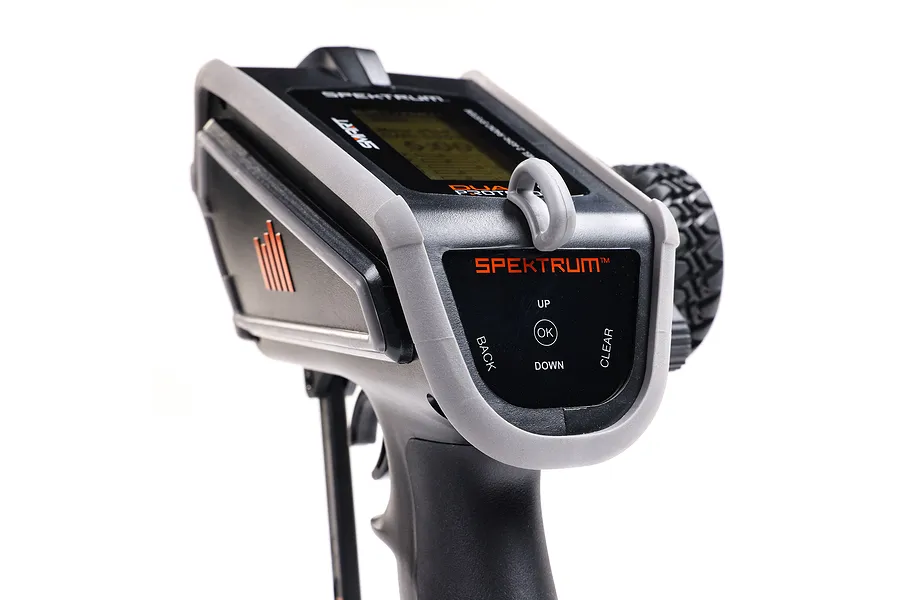 Close-up of the top control panel of a Spektrum DX Rugged RC transmitter featuring a grey protective bumper, LCD screen, and navigation buttons.