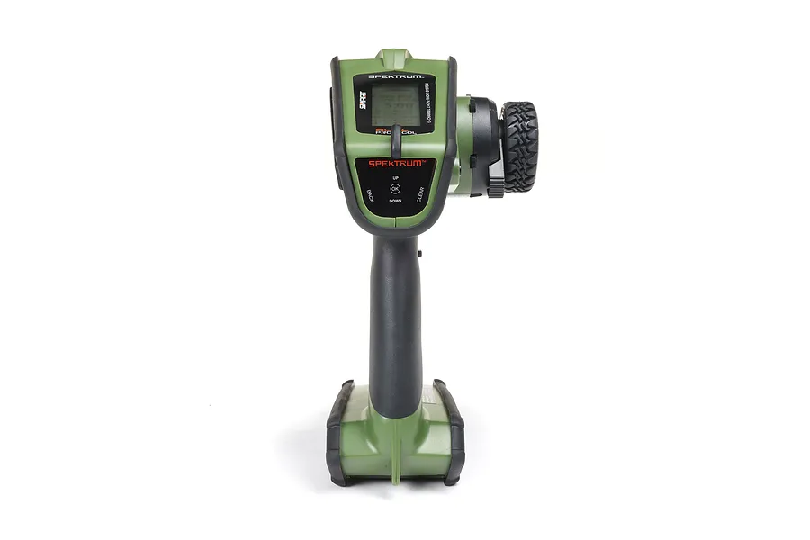 A front-facing studio shot of the Spektrum DX Rugged green RC transmitter with a black steering wheel on the right side.
