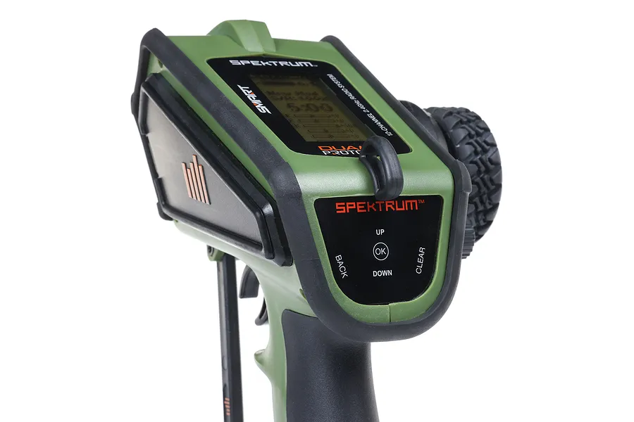 Close-up of the Spektrum DX Rugged green RC transmitter showing the top control panel, display, and steering wheel.