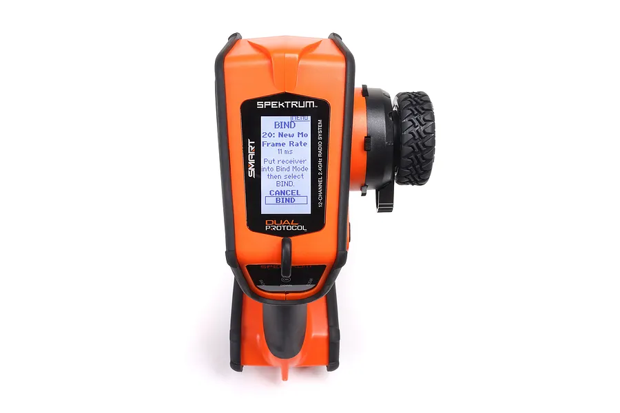 Spektrum DX Rugged orange 12-channel RC transmitter showing the bind menu on its digital display screen.