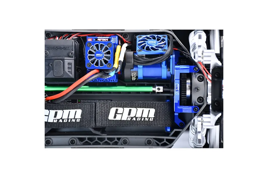 Top-down view of an RC car chassis featuring a blue GPM Racing aluminium motor mount installed with a cooling fan.